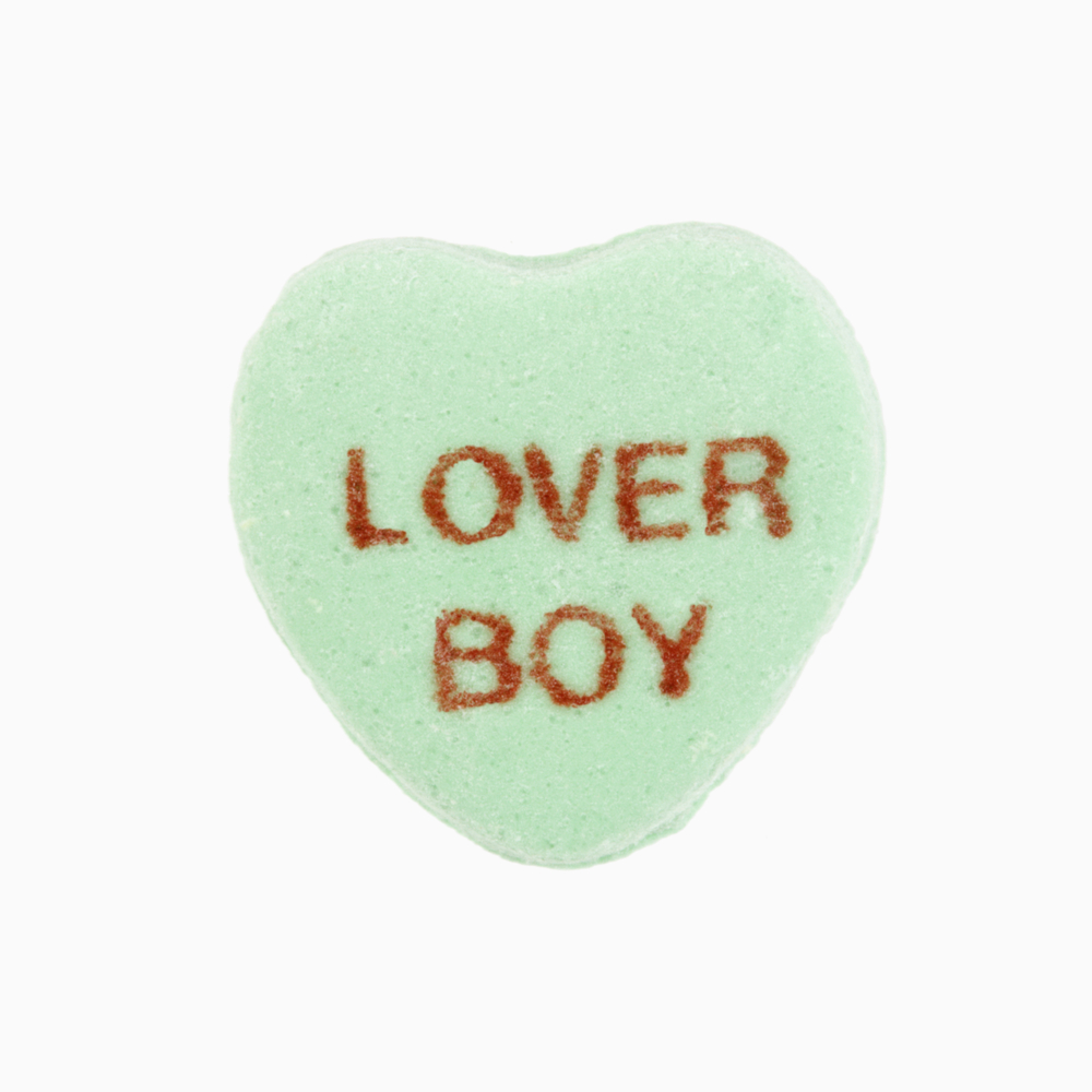 Green candy heart that reads lover boy against white background.