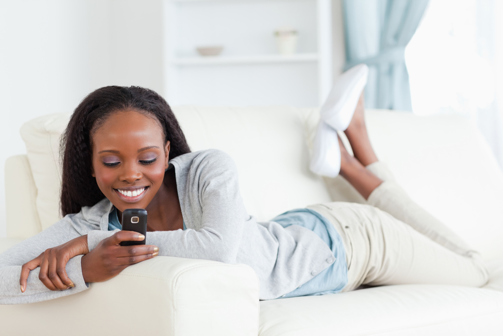 Woman texting on couch